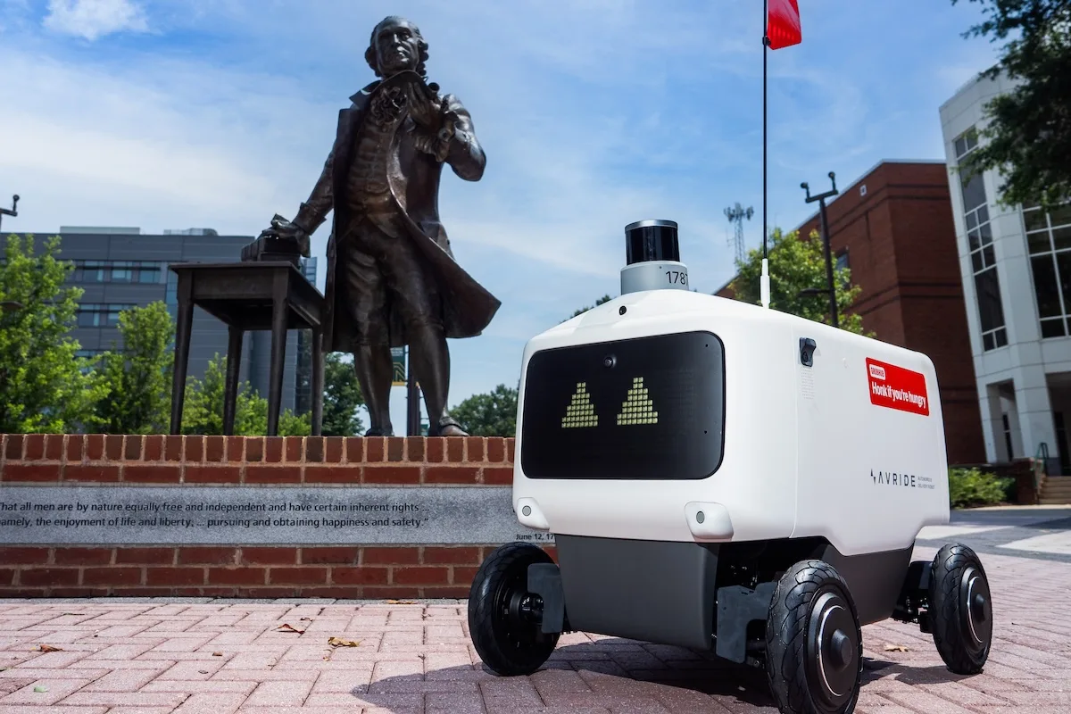 Photo of the AVRide, the new delivery robot in front of the George Mason Statue