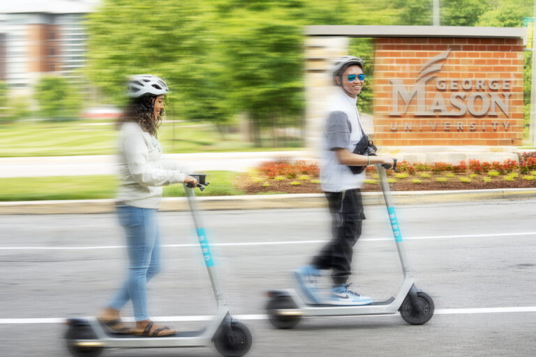 Students riding scooters to class on the Fairfax Campus. photo by Evan Cantwell/Office of University Branding